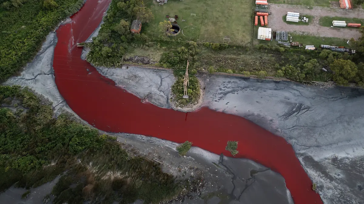 06.02.2025, Argentinien, Buenos Aires: Eine Luftaufnahme zeigt den «Sarandí»-Fluss in einem Industriegebiet am Rande von Buenos Aires, dessen Wasser sich intensiv rot verfärbt hat. Anwohner vermuten, dass unbekannte Schadstoffe für die auffällige Färbung verantwortlich sind. Das Umweltministerium hat Wasserproben entnommen, um die Ursache der Verfärbung zu ermitteln Foto: Rodrigo Abd/AP/dpa +++ dpa-Bildfunk +++