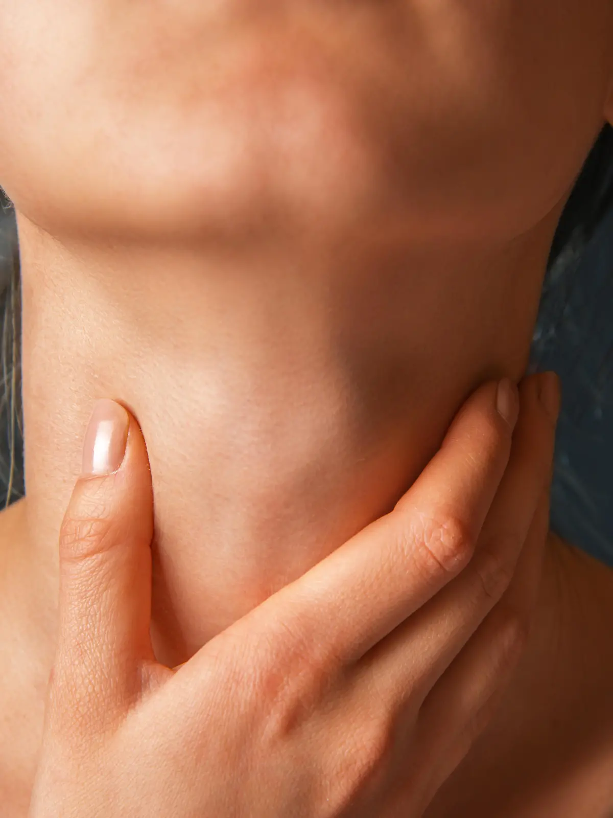 Unrecognizable woman holds her throat, sore throat