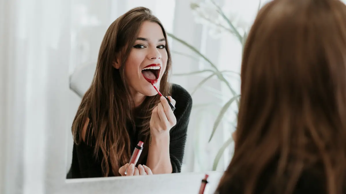 Frau trägt roten Lippenstift auf.