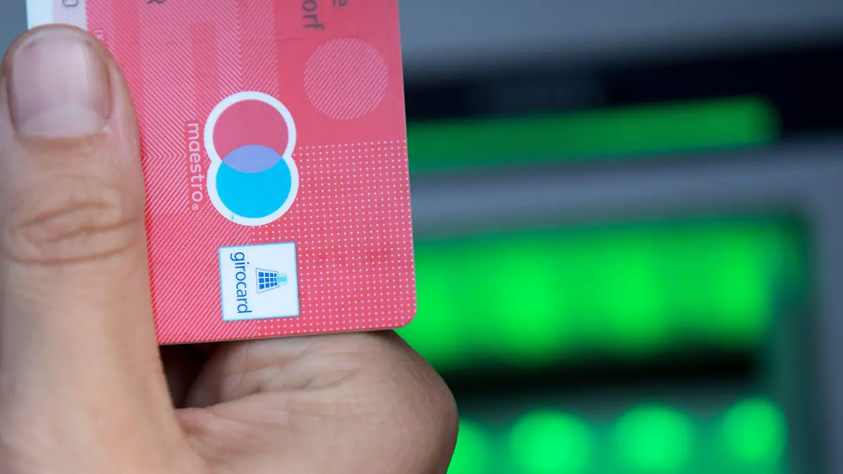 ARCHIV - 30.05.2018, Berlin: Eine Bankkundin hebt mit ihrer Girokarte, mit rot-blauem Maestro-Logo, Bargeld von einem Geldautomaten ab. (zu dpa: "Girocard ohne Maestro: Was sich für Bankkunden ändert und was nicht") Foto: Fabian Sommer/dpa +++ dpa-Bildfunk +++