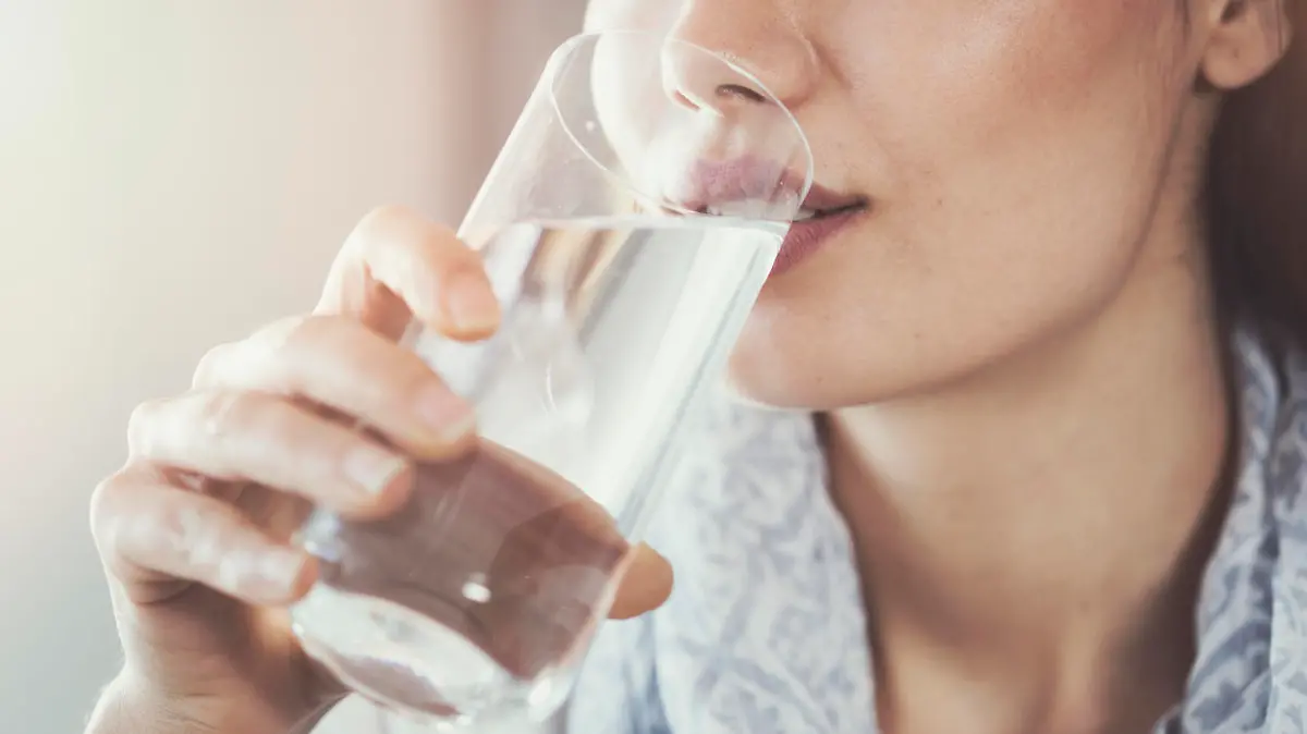 Young woman drinking pure glass of water