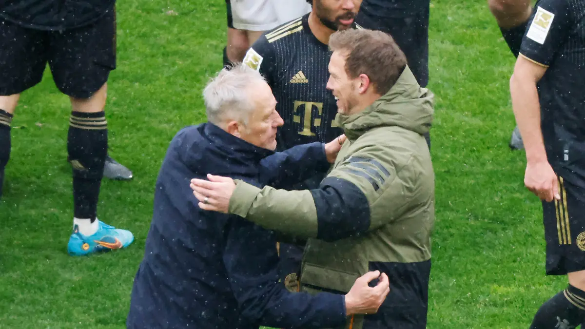 02.04.2022, Baden-Württemberg, Freiburg im Breisgau: Fußball: Bundesliga, SC Freiburg - Bayern München, 28. Spieltag, Europa-Park Stadion: Freiburgs Trainer Christian Streich (l) und Münchens Cheftrainer Julian Nagelsmann (r) verabschieden sich nach Spielende voneinander, dahinter geht Münchens Serge Gnabry. Foto: Philipp von Ditfurth/dpa - WICHTIGER HINWEIS: Gemäß den Vorgaben der DFL Deutsche Fußball Liga bzw. des DFB Deutscher Fußball-Bund ist es untersagt, in dem Stadion und/oder vom Spiel angefertigte Fotoaufnahmen in Form von Sequenzbildern und/oder videoähnlichen Fotostrecken zu verwerten bzw. verwerten zu lassen. +++ dpa-Bildfunk +++