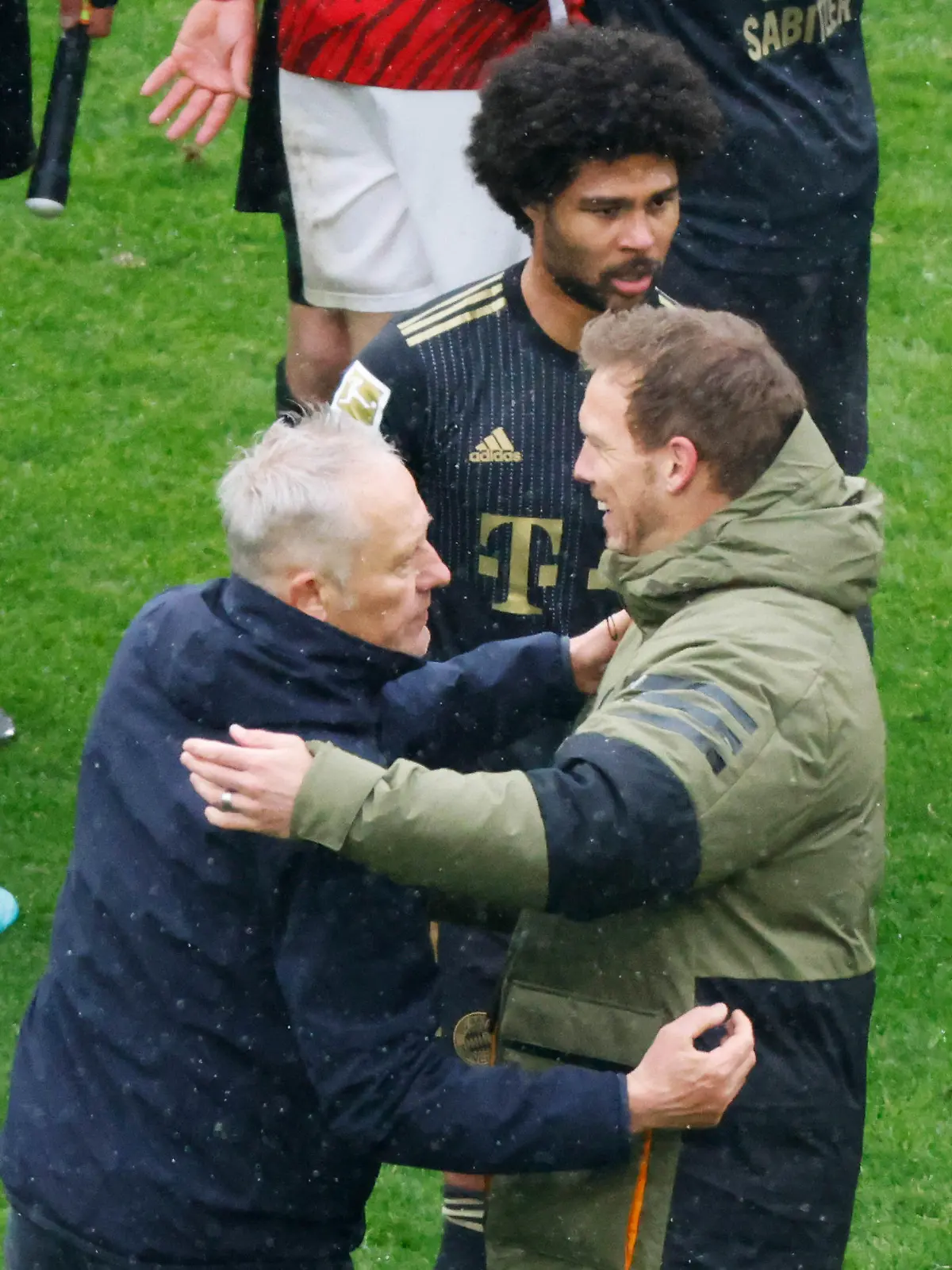 02.04.2022, Baden-Württemberg, Freiburg im Breisgau: Fußball: Bundesliga, SC Freiburg - Bayern München, 28. Spieltag, Europa-Park Stadion: Freiburgs Trainer Christian Streich (l) und Münchens Cheftrainer Julian Nagelsmann (r) verabschieden sich nach Spielende voneinander, dahinter geht Münchens Serge Gnabry. Foto: Philipp von Ditfurth/dpa - WICHTIGER HINWEIS: Gemäß den Vorgaben der DFL Deutsche Fußball Liga bzw. des DFB Deutscher Fußball-Bund ist es untersagt, in dem Stadion und/oder vom Spiel angefertigte Fotoaufnahmen in Form von Sequenzbildern und/oder videoähnlichen Fotostrecken zu verwerten bzw. verwerten zu lassen. +++ dpa-Bildfunk +++
