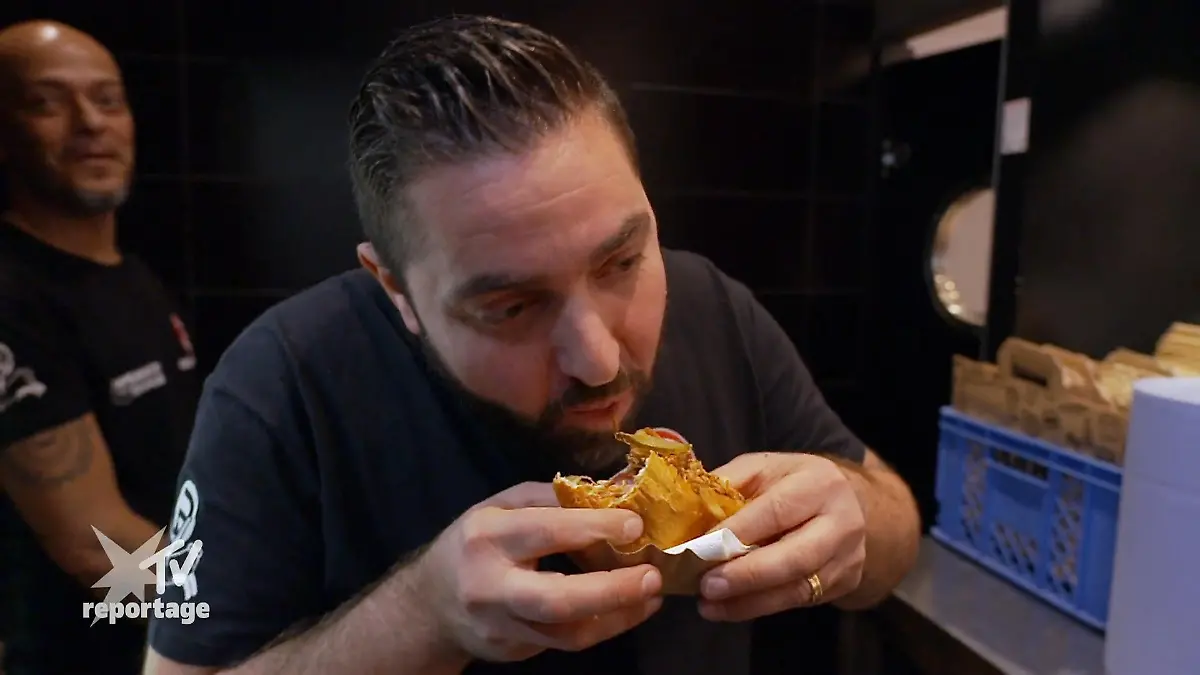 Lars präsentiert den Hot Dog seinem Geschäftspartner Neues Experiment