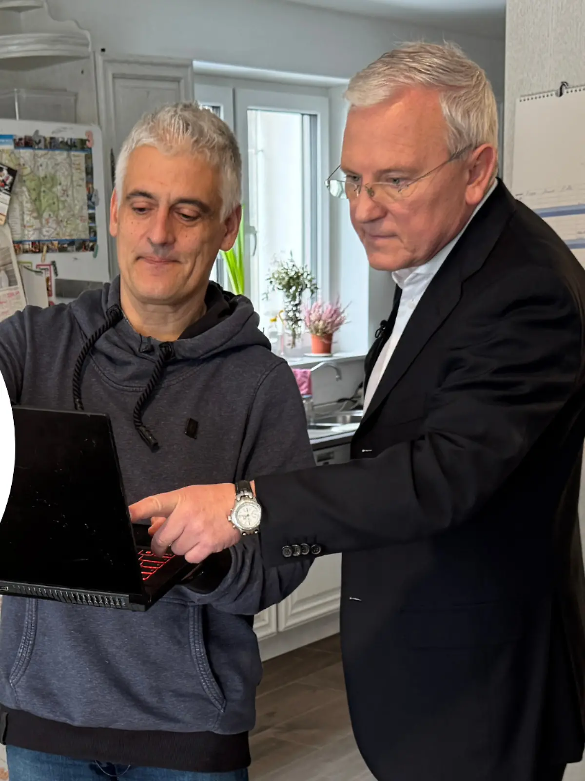 Reporter Robert Keckeis schaut sich mit Opfer etwas auf dem Laptop an