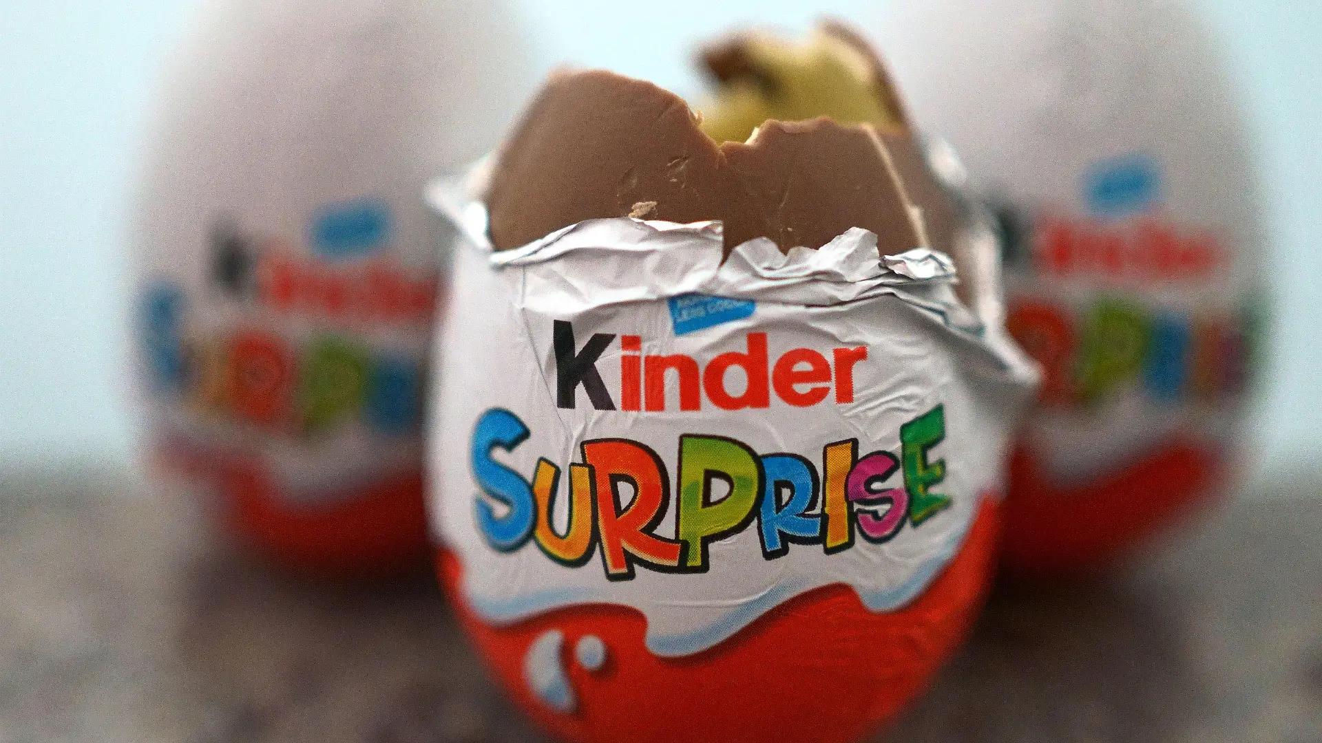 04.04.2022, Großbritannien, London: Drei britische Varianten der Kinder-Überraschungseier liegen auf einem Tisch. (zu dpa: "Salmonellen-Gefahr: Ferrero ruft auch in Australien Produkte zurück") Foto: Victoria Jones/PA Wire/dpa +++ dpa-Bildfunk +++