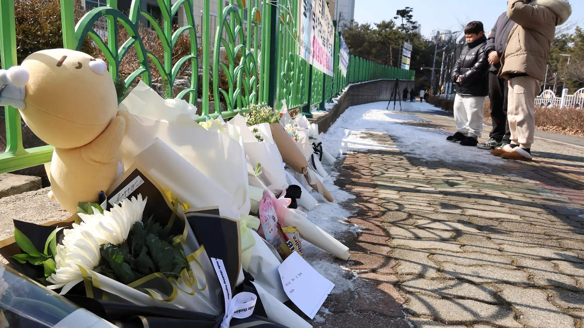 Vor der Schule haben viele Menschen Blumen, Spielzeug und Nachrichten zum Gedenken an das ermordete Mädchen abgelegt. 