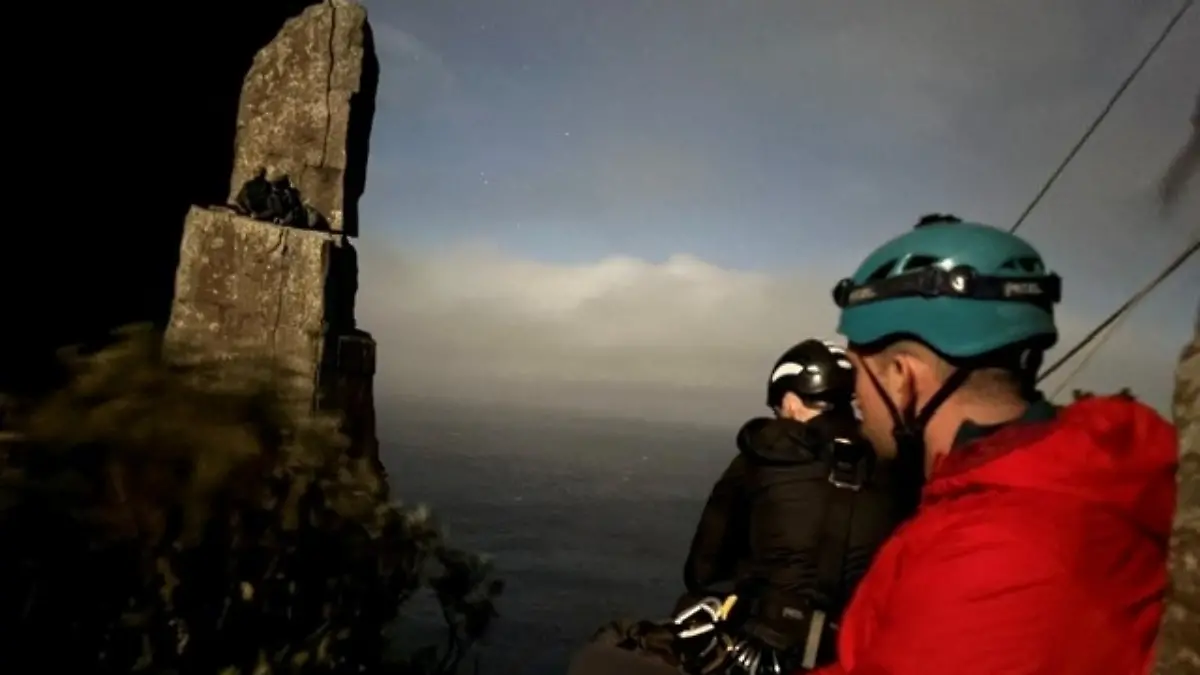 Das von der Polizei in Tasmanien zur Verfügung gestellte Foto zeigt Retter und zwei Kletterer, die auf dem Totem Pole festsitzen.