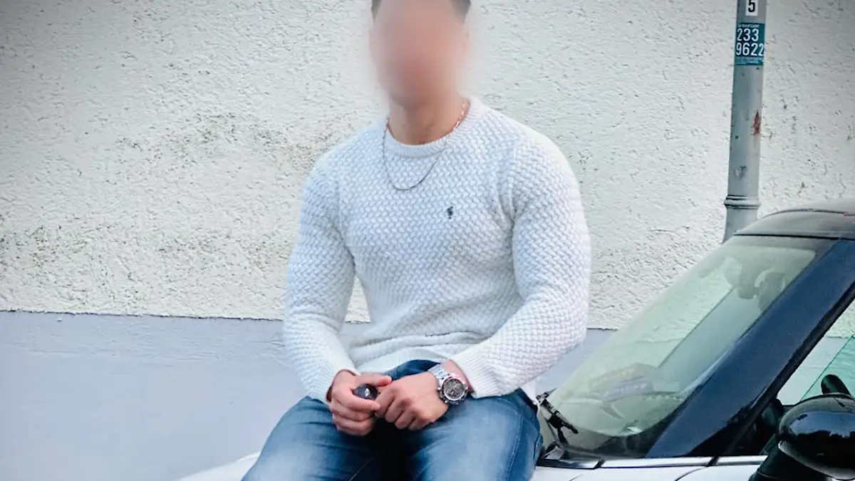 Der festgenommene Afghane Farhad N. (24) sitzt auf der Motorhaube eines Autos.