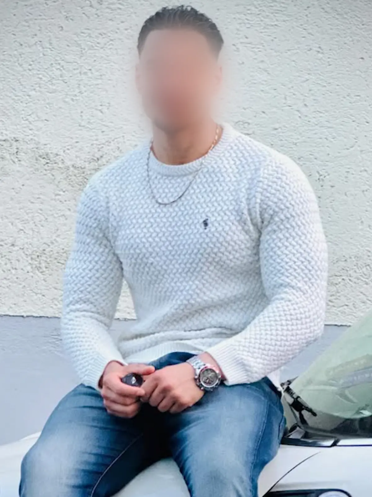 Der festgenommene Afghane Farhad N. (24) sitzt auf der Motorhaube eines Autos.