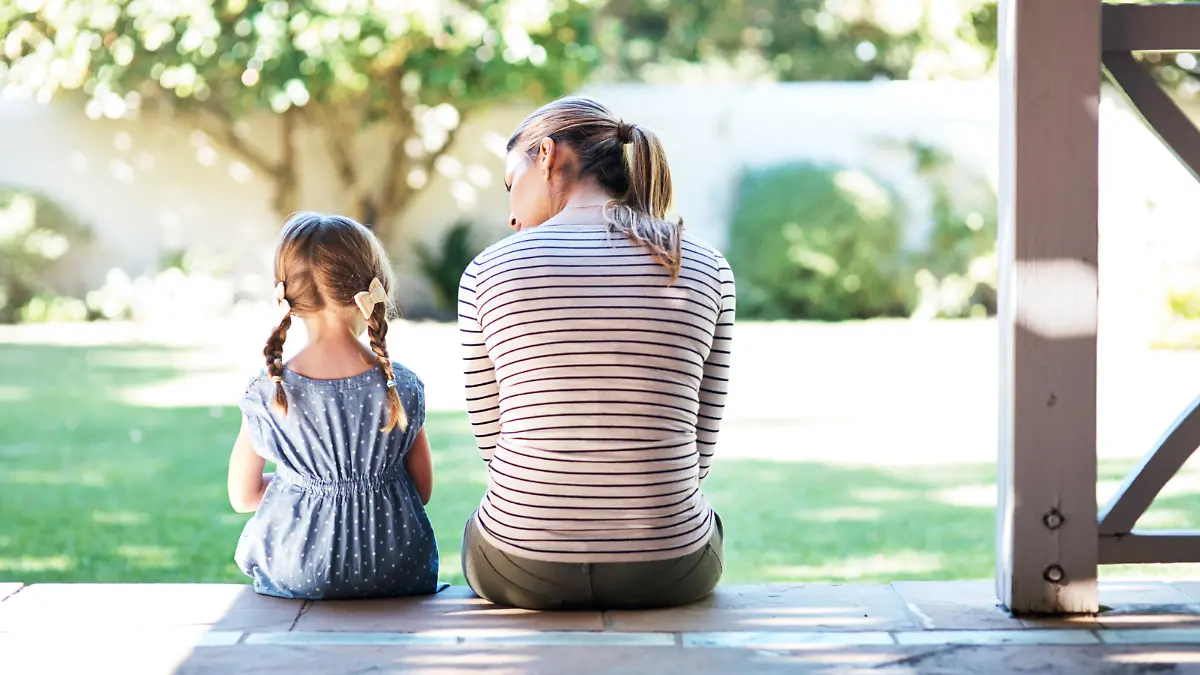 Rearview shot of a young woman and her daughter having a conversation on the porch