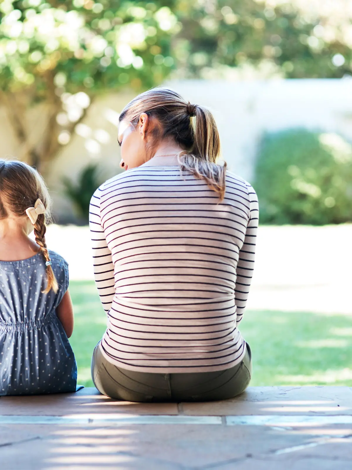 Rearview shot of a young woman and her daughter having a conversation on the porch