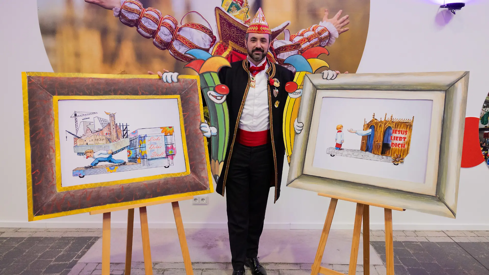 Der Kölner Zugleiter Marc Michelske präsentiert Skizzen, die einen geplanten Motivwagen zum Thema Missbrauch in der Kirche (r) und Baustellen in Köln für den Rosenmontagszug zeigt