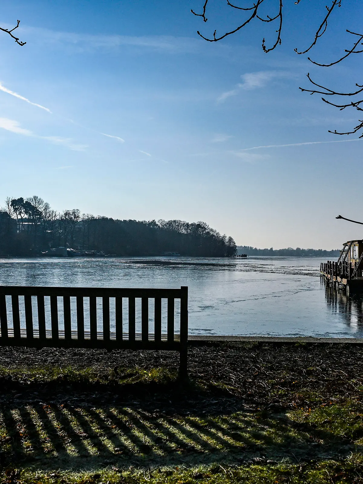 04.02.2025, Brandenburg, Woltersdorf: Lange Schatten lässt die tiefstehende Sonne am Ufer des Flakensees entstehen. Nach Sonnenschein bei kühlen Temperaturen am Tage werden in der Nacht moderate Minustemperaturen erreicht. Foto: Jens Kalaene/dpa +++ dpa-Bildfunk +++