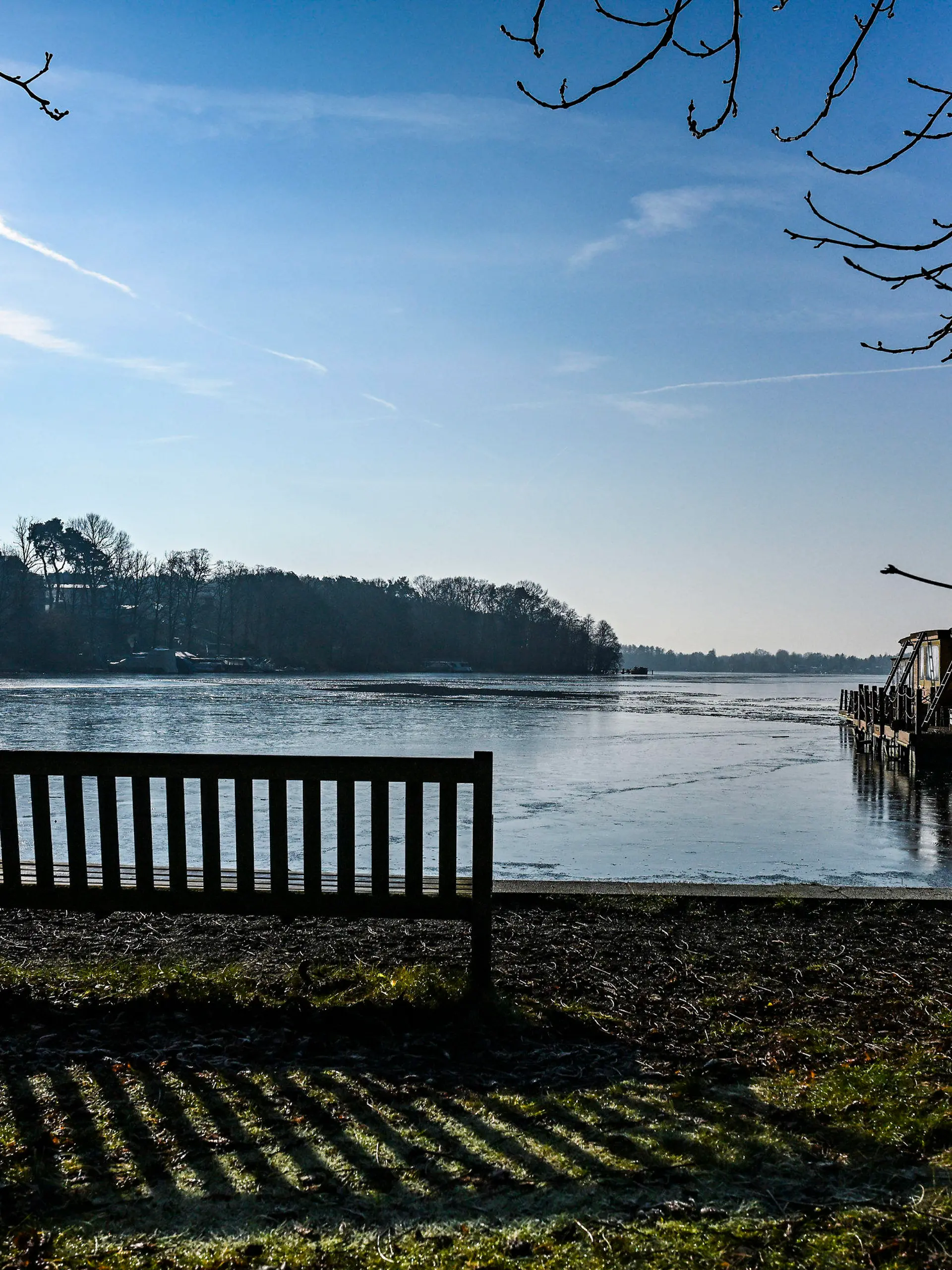 04.02.2025, Brandenburg, Woltersdorf: Lange Schatten lässt die tiefstehende Sonne am Ufer des Flakensees entstehen. Nach Sonnenschein bei kühlen Temperaturen am Tage werden in der Nacht moderate Minustemperaturen erreicht. Foto: Jens Kalaene/dpa +++ dpa-Bildfunk +++