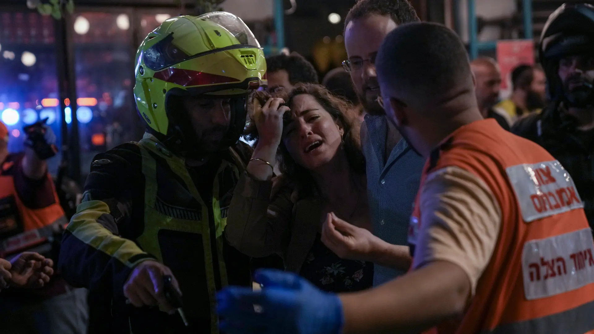 A woman reacts at the scene of a shooting attack In Tel Aviv, Israel, Thursday, April 7, 2022. Israeli police say several people were wounded in a shooting in central Tel Aviv. The shooting on Thursday evening occurred in a crowded area with several bars and restaurants. (AP Photo/Ariel Schalit)