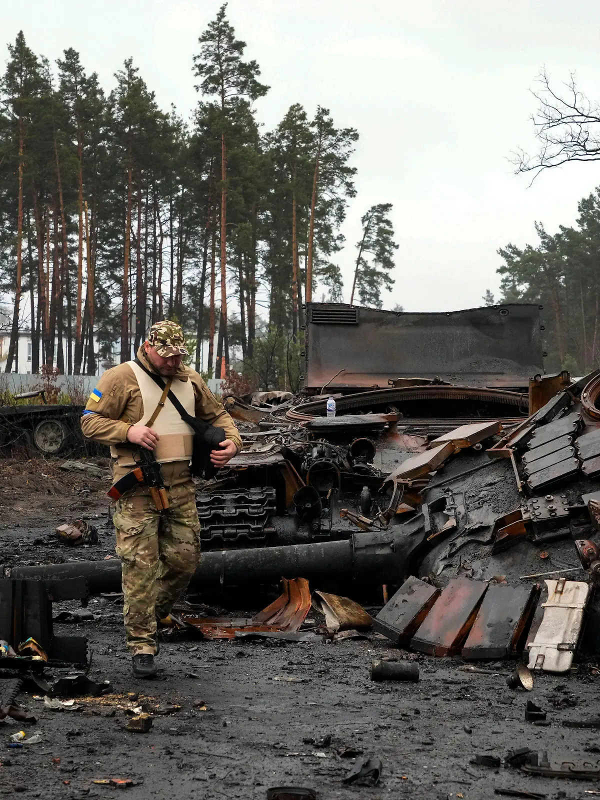 02.04.2022, Ukraine, Dmytriwka: Ein ukrainischer Soldat geht auf einer Straße an einen zerstörten russischen Panzer vorbei. Foto: Efrem Lukatsky/AP/dpa +++ dpa-Bildfunk +++