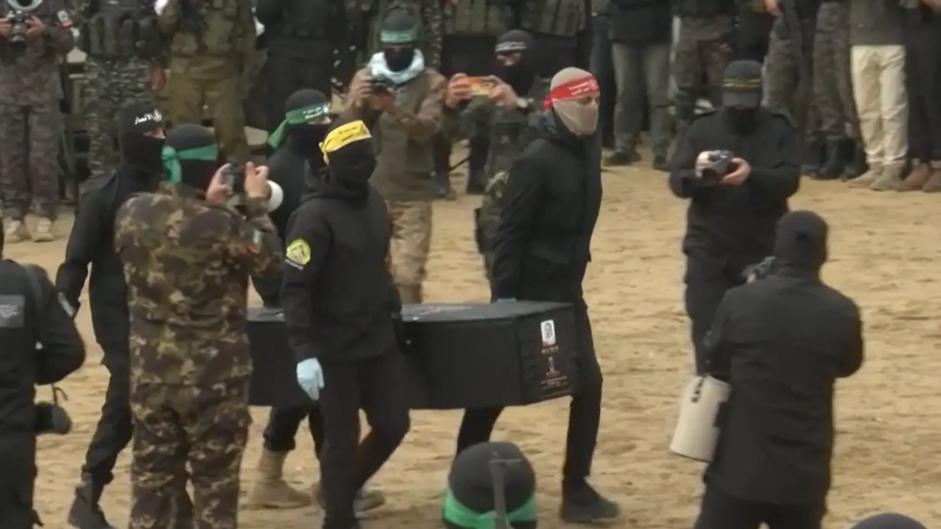 Mitglieder der Hamas tragen einen Sarg mit einer toten Geisel darin.