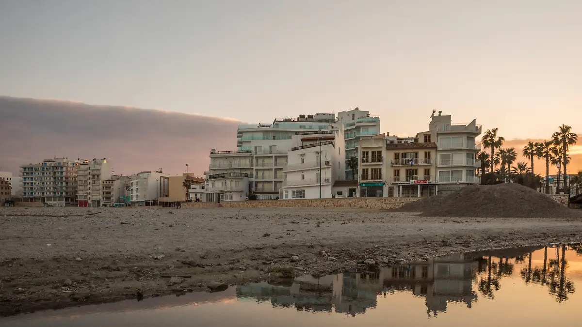 20. Januar 2022, Sa Coma, Mallorca, Spanien: Abendstimmung am Strand S’lllot mit sich im Wasser spiegelnder Skyline in Sa Coma auf Mallorca.