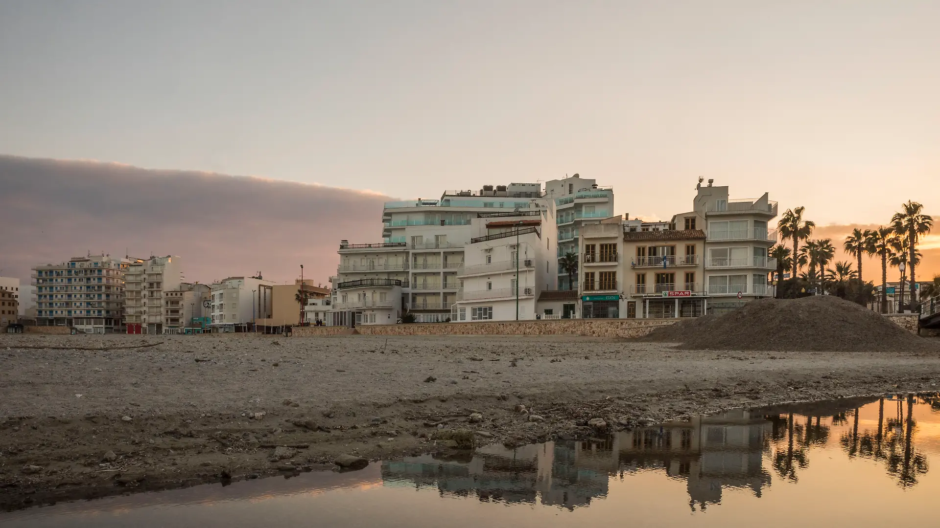 20. Januar 2022, Sa Coma, Mallorca, Spanien: Abendstimmung am Strand S’lllot mit sich im Wasser spiegelnder Skyline in Sa Coma auf Mallorca. 