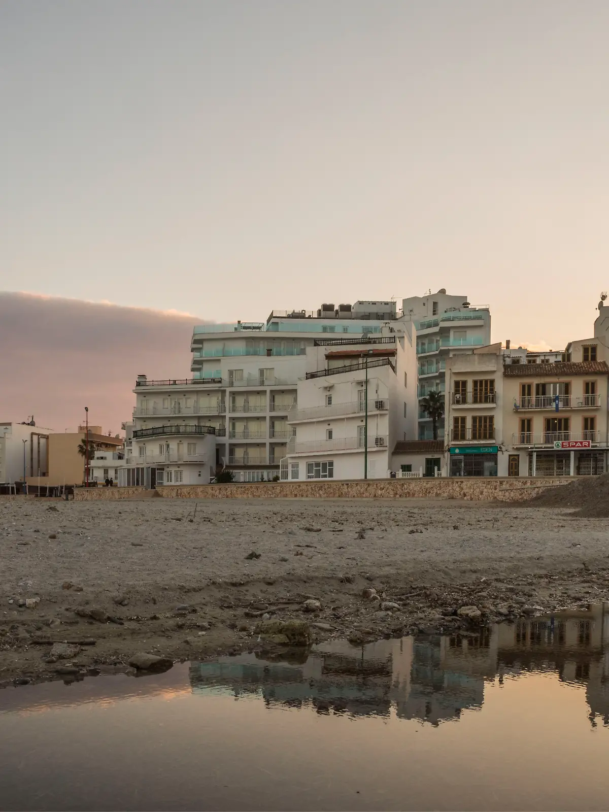 20. Januar 2022, Sa Coma, Mallorca, Spanien: Abendstimmung am Strand S’lllot mit sich im Wasser spiegelnder Skyline in Sa Coma auf Mallorca. 