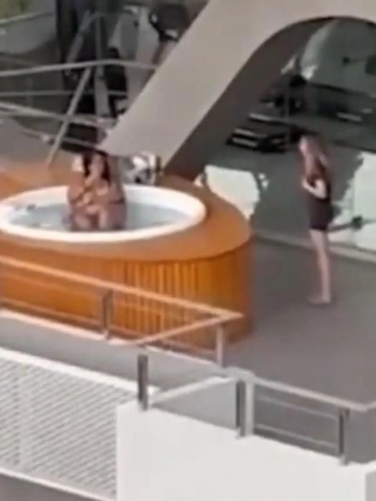 Ein Paar hat Sex in einem Whirlpool auf einem Balkon eines Gebäudekomplexes. 