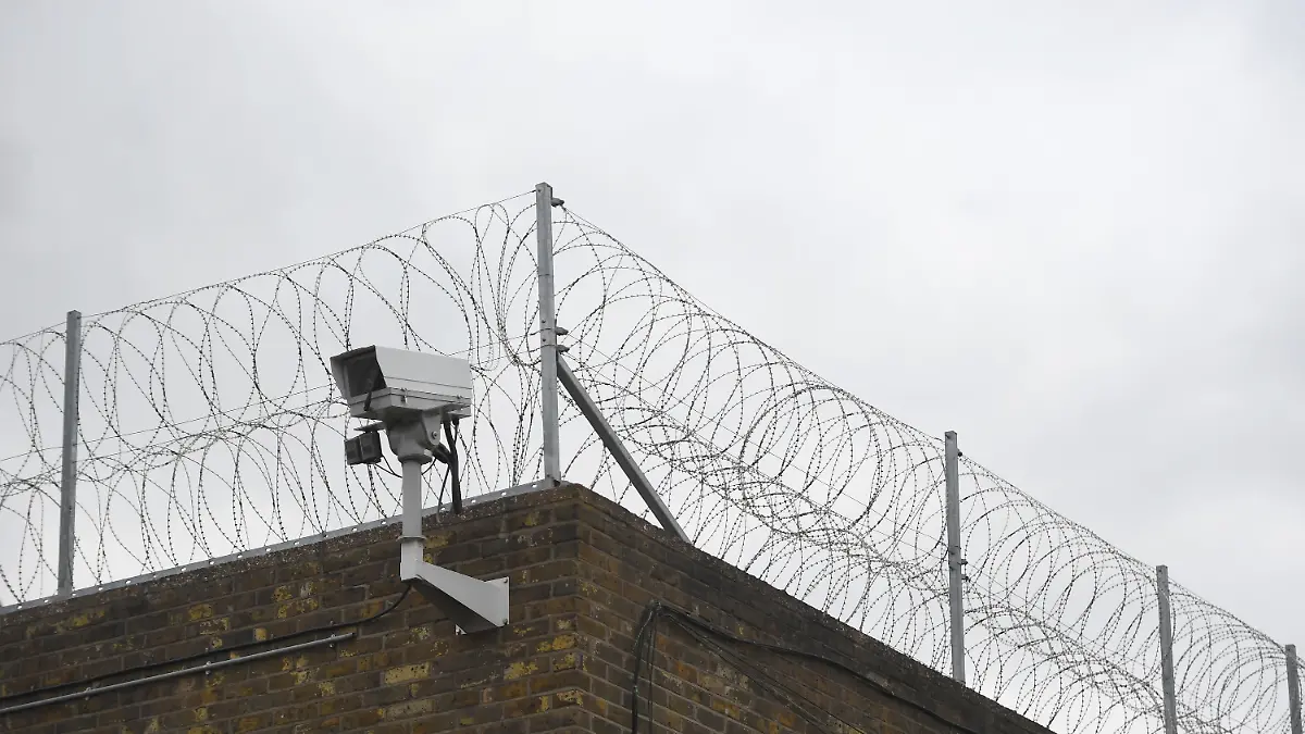 Ein Zaun und eine Überwachungskamera an der Mauer eines Gefängnisses in Großbritannien 