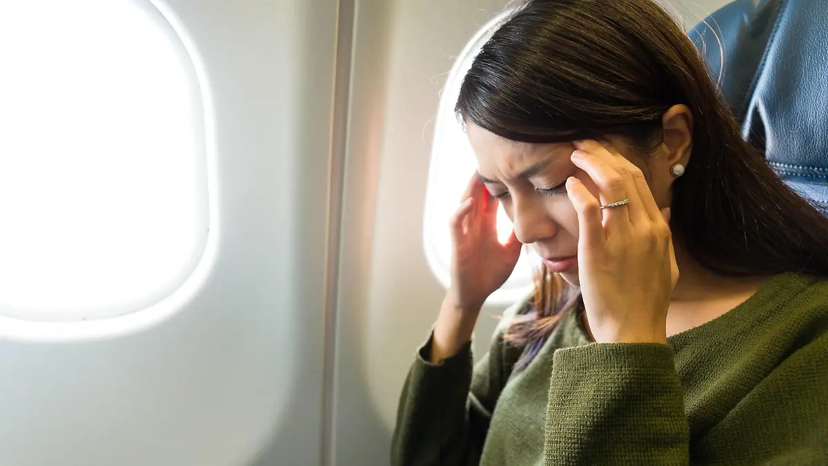 frau in der ebene leidet unter airsick mit stress kopfschmerzen || Modellfreigabe vorhanden