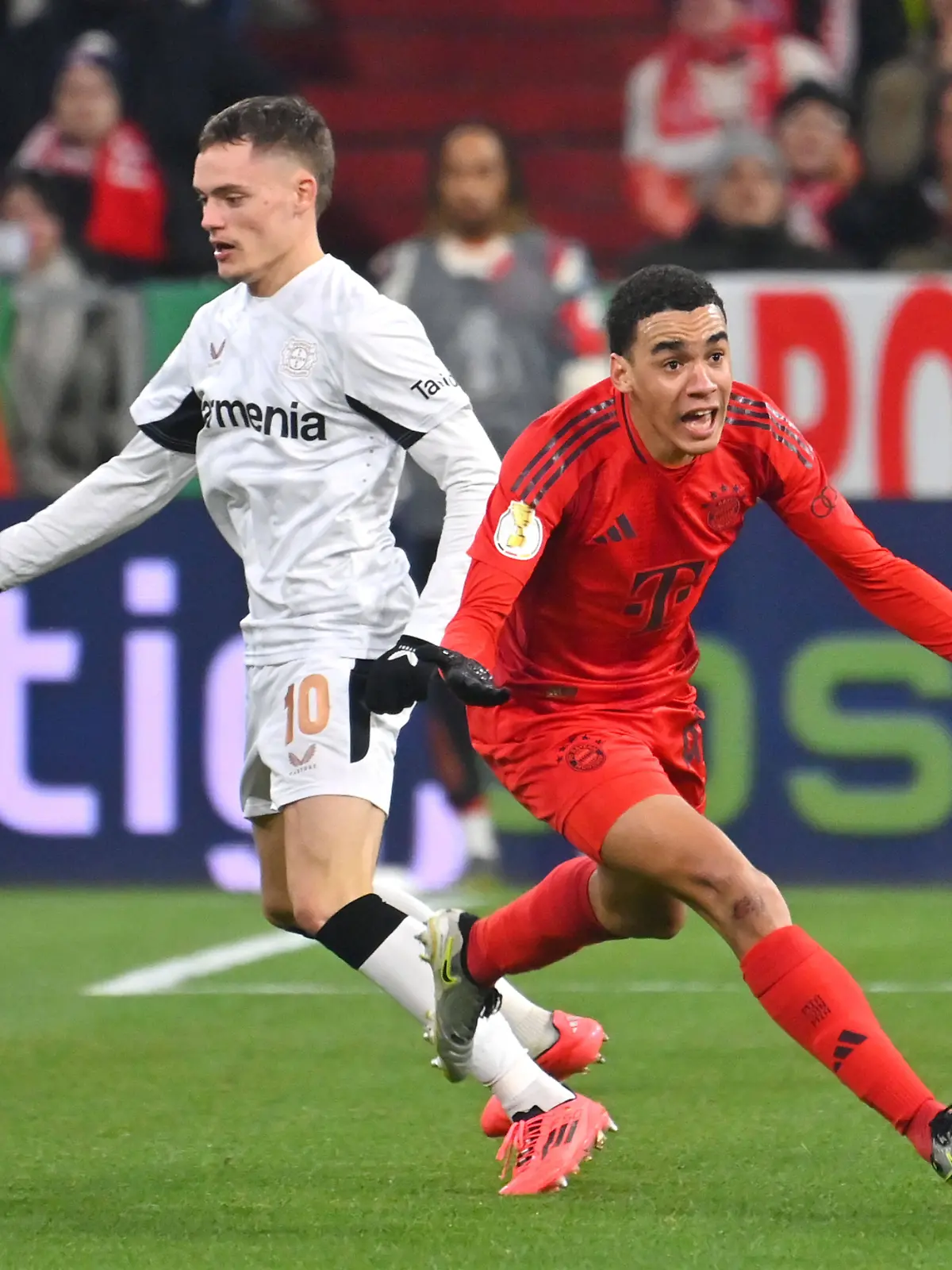 Bayern Münchens Jamal Musiala im Duell mit Florian Wirtz und Robert Andrich von Bayer Leverkusen im Achtefinale des DFB-Pokals 2024/25