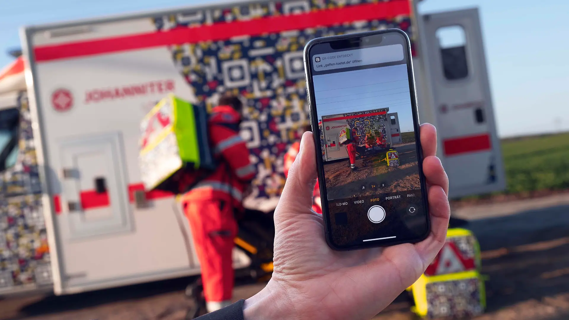 HANDOUT - 19.04.2021, ---: In einer gestellten Szene der Johanniter-Unfall-Hilfe ist auf einem Smartphone der QR-Code auf einem Rettungswagen zu sehen, der die Botschaft «Gaffen tötet» enthält. Dieser soll auf Smartphones von Schaulustigen erscheinen, wenn sie Unfall-Einsätze der Johanniter fotografieren wollen. (zu dpa "Projekt: QR-Code an Rettungswagen soll Unfall-«Gaffer» abschrecken") Foto: André Wagenzik/Scholz & Friends/Johanniter-Unfall-Hilfe/dpa - ACHTUNG: Nur zur redaktionellen Verwendung im Zusammenhang mit einer Berichterstattung über das Projekt «Gaffen tötet» und nur mit vollständiger Nennung des vorstehenden Credits +++ dpa-Bildfunk +++