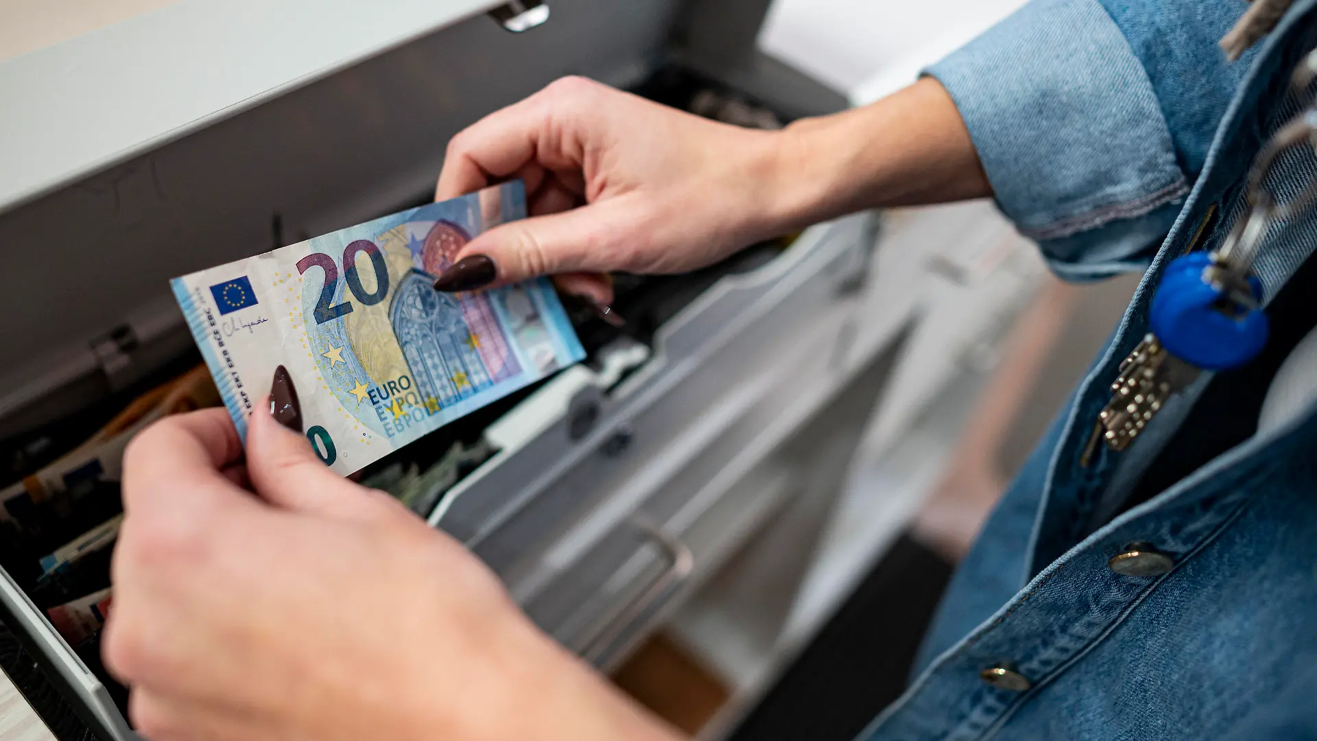 PRODUKTION - 02.03.2022, Berlin: Eine Mitarbeiterin legt Geld in die Kasse in einem Bekleidungsladen in einem Einkaufscenter in Berlin-Marzahn. Das ifo Institut veröffentlicht am 25.03.2022 seinen monatlichen Geschäftsklimaindex. Foto: Fabian Sommer/dpa +++ dpa-Bildfunk +++