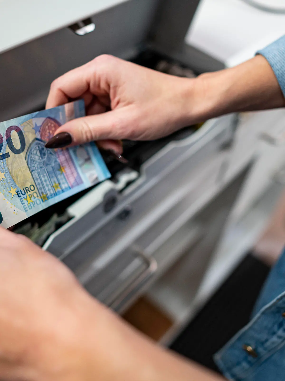 PRODUKTION - 02.03.2022, Berlin: Eine Mitarbeiterin legt Geld in die Kasse in einem Bekleidungsladen in einem Einkaufscenter in Berlin-Marzahn. Das ifo Institut veröffentlicht am 25.03.2022 seinen monatlichen Geschäftsklimaindex. Foto: Fabian Sommer/dpa +++ dpa-Bildfunk +++