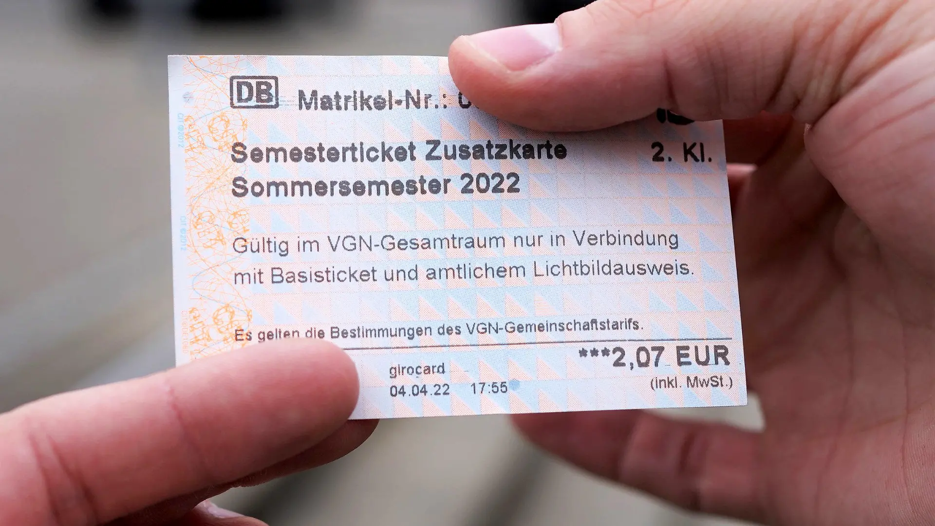 05.04.2022, Bayern, Nürnberg: Ein Student hält ein Semesterticket für den Verkehrsverbund Großraum Nürnberg. Wegen eines Fehlers wurden die Fahrkarten an Automaten vorübergehend für 2,07 Euro statt 207 Euro verkauft. Es war zunächst unklar, ob die Tickets gültig bleiben. (zu dpa: «99 Prozent «Rabatt» - Fehler verhilft Studierenden zu Billig-Tickets») Foto: Gregor Bauernfeind/dpa +++ dpa-Bildfunk +++