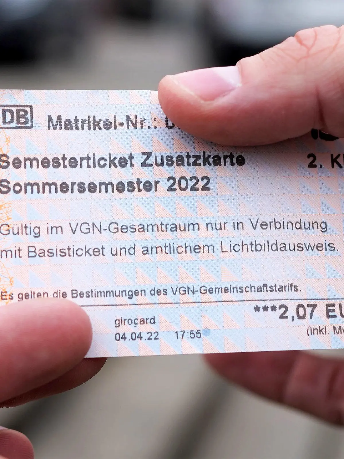 05.04.2022, Bayern, Nürnberg: Ein Student hält ein Semesterticket für den Verkehrsverbund Großraum Nürnberg. Wegen eines Fehlers wurden die Fahrkarten an Automaten vorübergehend für 2,07 Euro statt 207 Euro verkauft. Es war zunächst unklar, ob die Tickets gültig bleiben. (zu dpa: «99 Prozent «Rabatt» - Fehler verhilft Studierenden zu Billig-Tickets») Foto: Gregor Bauernfeind/dpa +++ dpa-Bildfunk +++