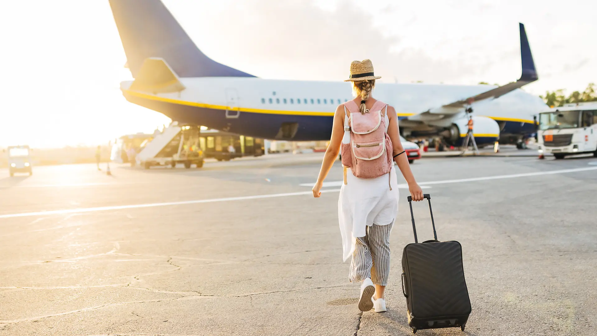Frau geht am Flughafen in Richtung Flugzeug