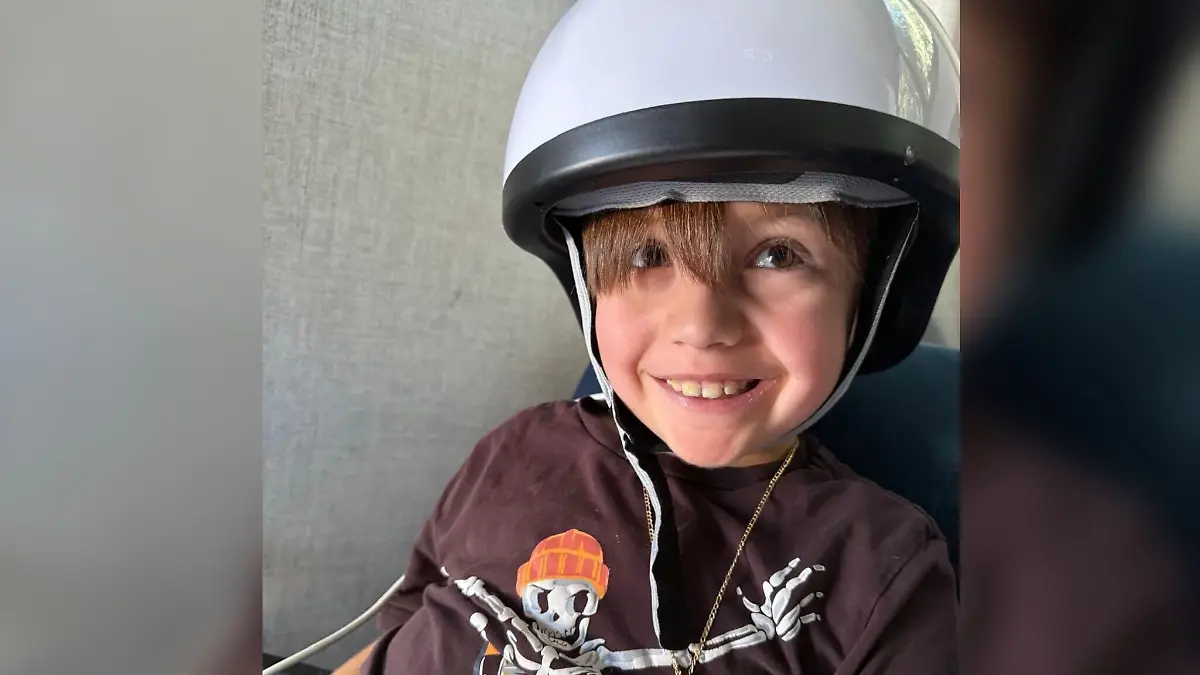 Junge mit Helm lacht in die Kamera