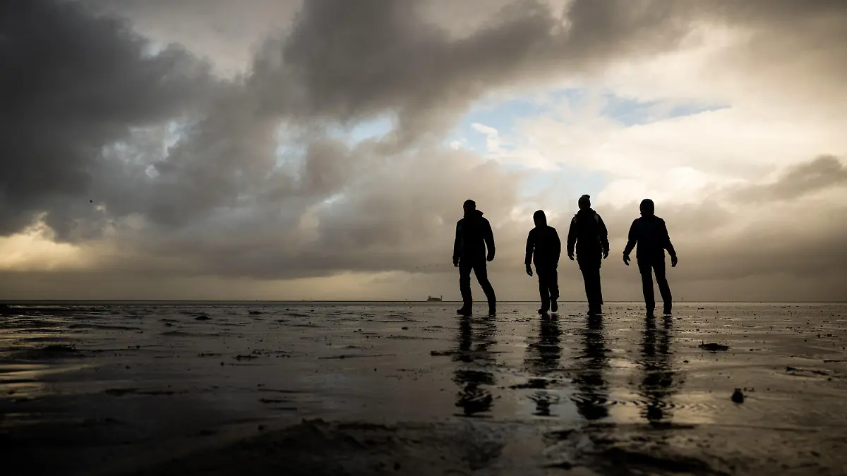 22.10.2021, Niedersachsen, Cuxhaven: Eine vierköpfige Familie aus Sachsen macht während ihres Urlaubs in Cuxhaven einen Wattspaziergang bei stürmischem Wetter am Strand Döse. Foto: Mohssen Assanimoghaddam/dpa +++ dpa-Bildfunk +++