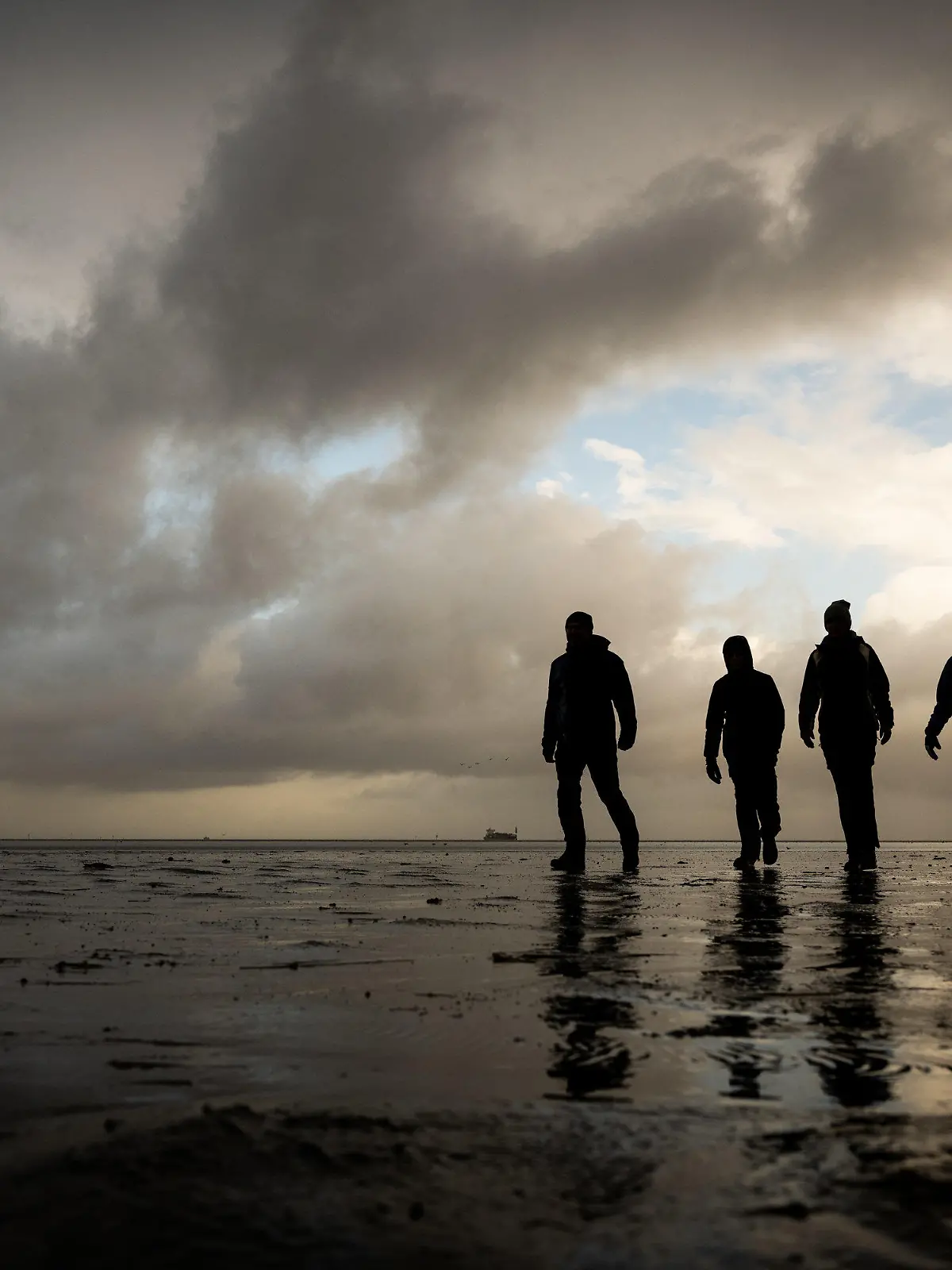 22.10.2021, Niedersachsen, Cuxhaven: Eine vierköpfige Familie aus Sachsen macht während ihres Urlaubs in Cuxhaven einen Wattspaziergang bei stürmischem Wetter am Strand Döse. Foto: Mohssen Assanimoghaddam/dpa +++ dpa-Bildfunk +++