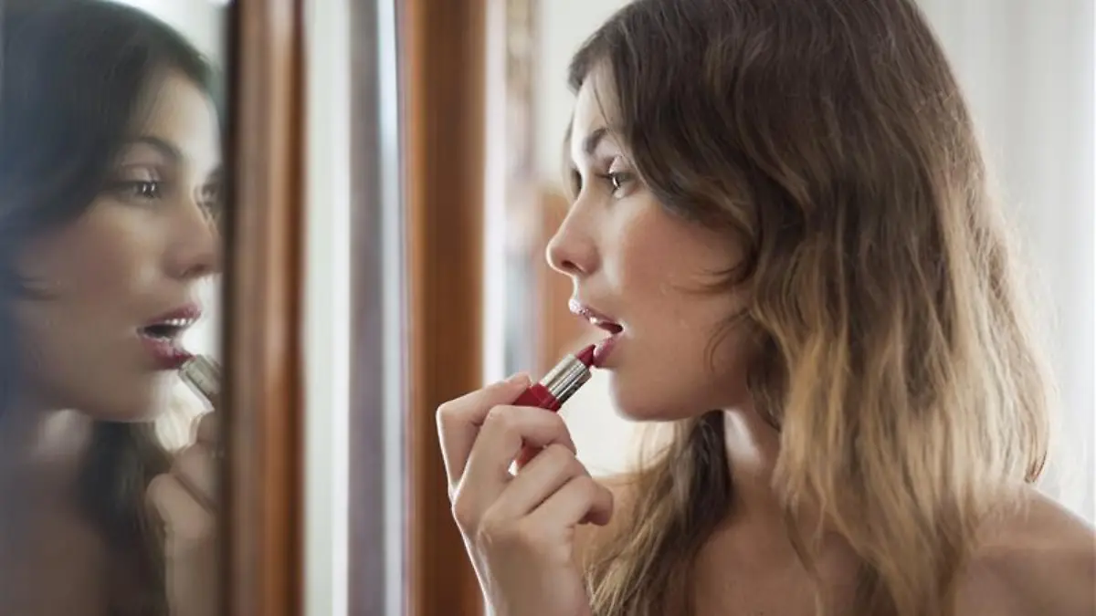 Frau trägt Lippenstift auf.