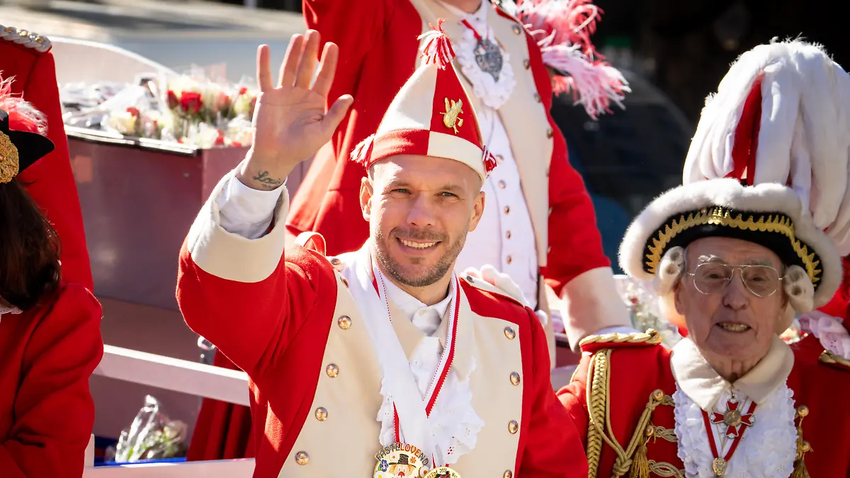 Lukas Podolski fährt auf dem Wagen der Roten Funken mit.