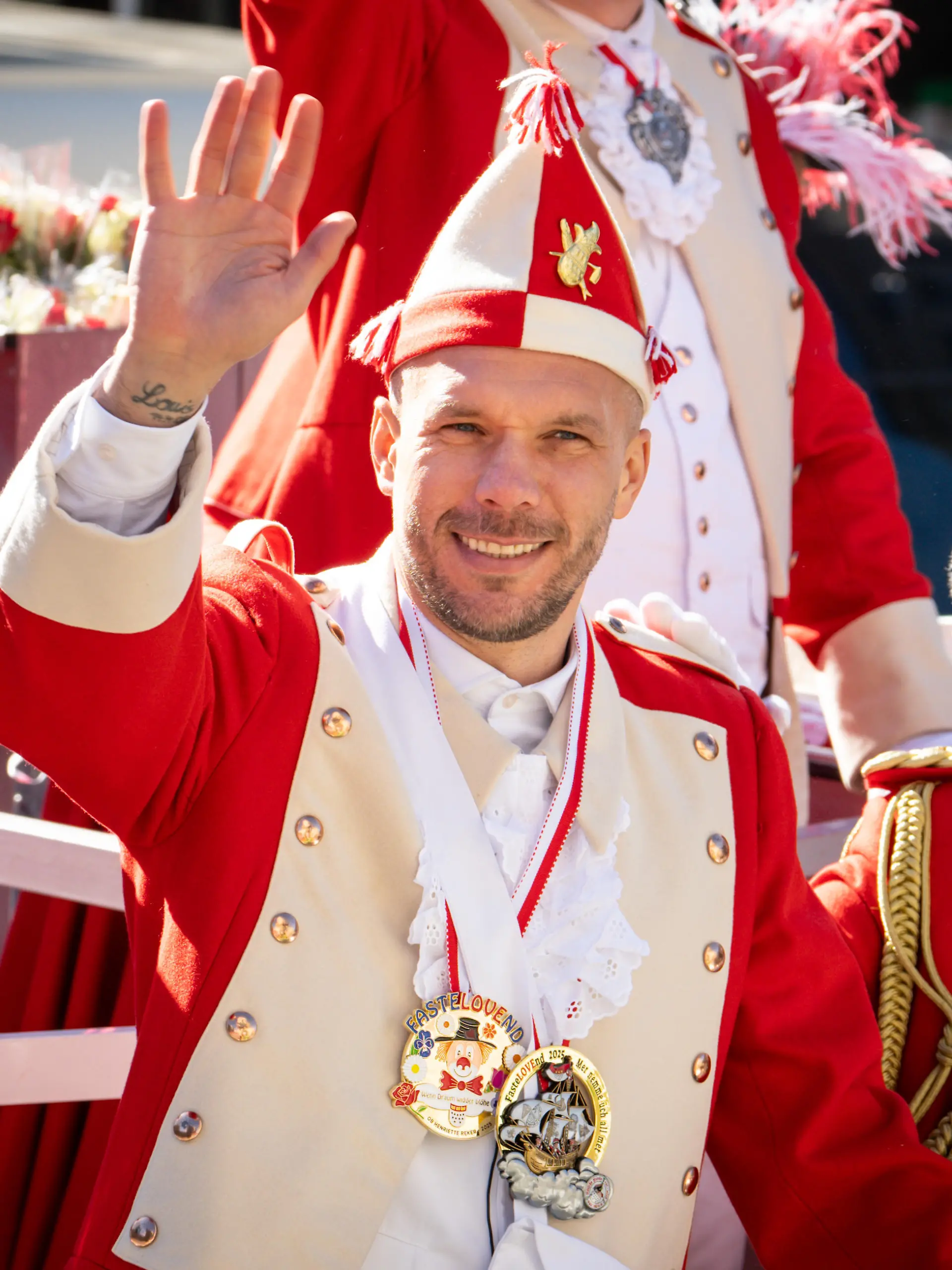 Lukas Podolski fährt auf dem Wagen der Roten Funken mit.