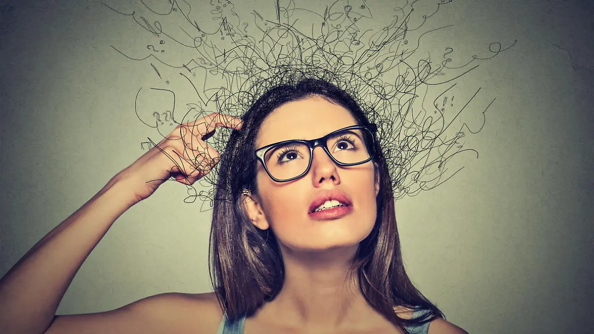Closeup portrait young woman scratching head, thinking daydreaming with brain melting into lines question marks looking up isolated on gray background. Human facial expressions, emotion feeling sign