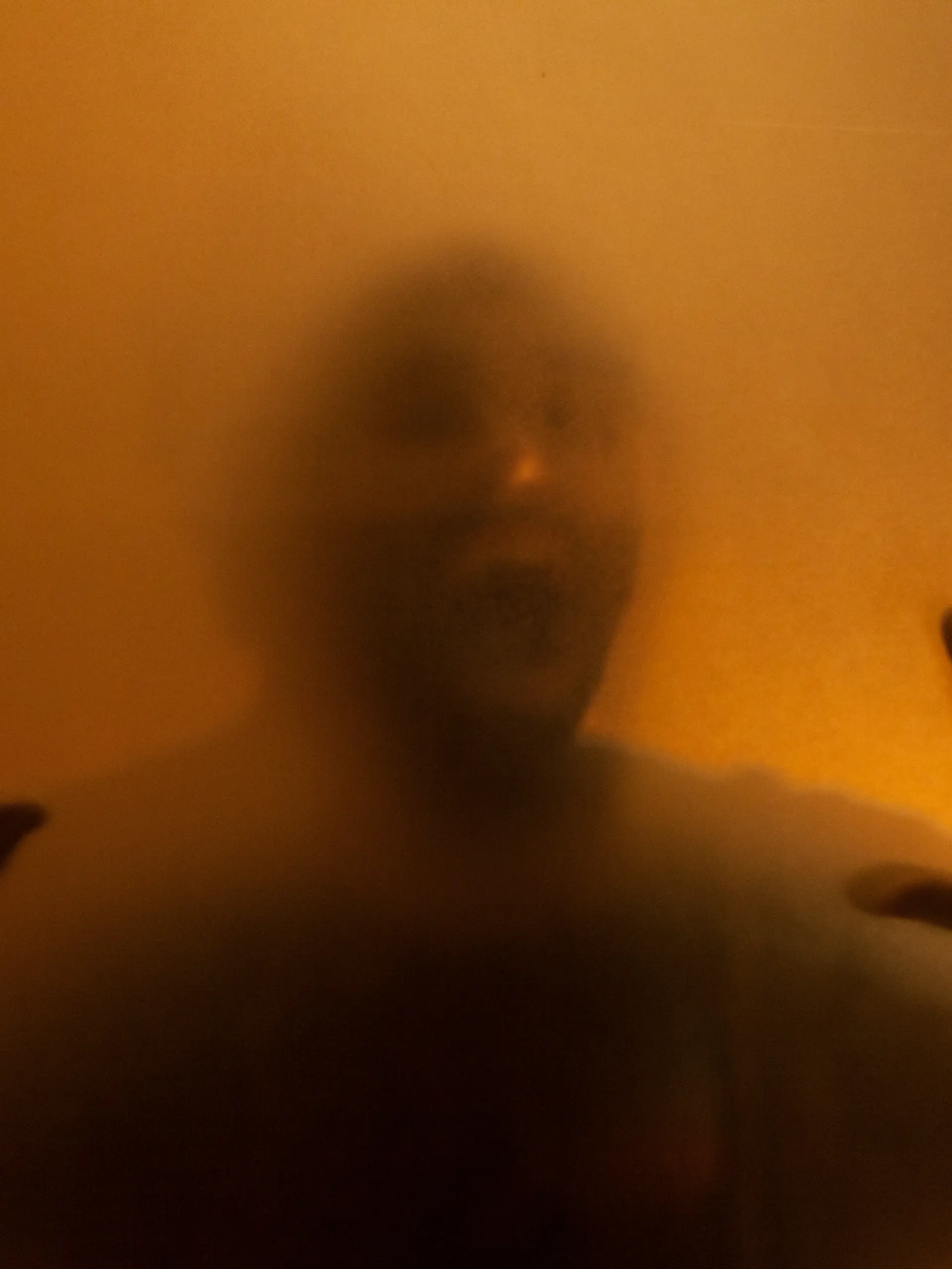 Man screaming with anger behind translucent surface