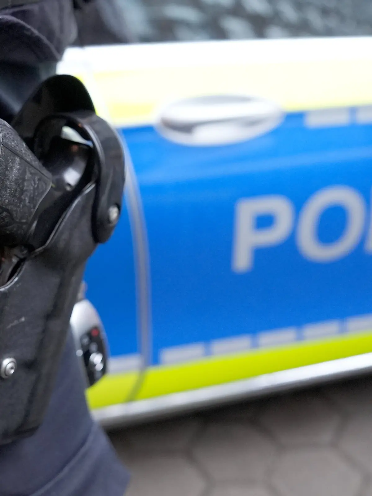 ARCHIV - 15.03.2024, Hamburg: Ein Polizist steht vor einem Einsatzfahrzeug der Polizei. (zu dpa: «Ermittlungen gegen Polizisten wegen rassistischer Chats») Foto: Marcus Brandt/dpa +++ dpa-Bildfunk +++