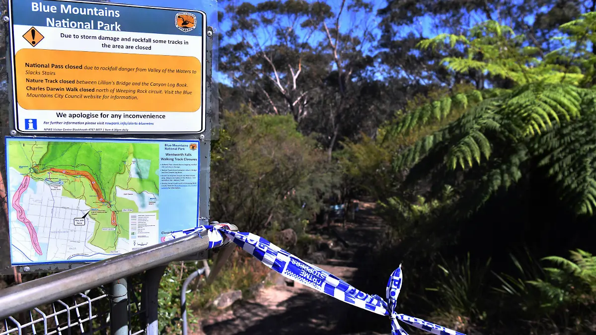 The entrance to the walking track where a landslide killed 2 and injured two others is tapped off at Wentworth Falls in the Blue Mountains, west of Sydney, Tuesday, April 5, 2022. A British family of five was caught in a landslide while walking in Australia's Blue Mountains, and the father and 9-year-old son died. (Dean Lewins/AAP Image via AP)