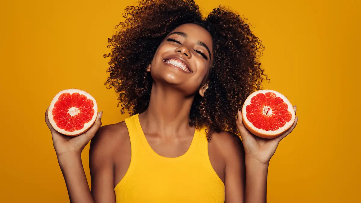Beautiful afro girl with grapefruit