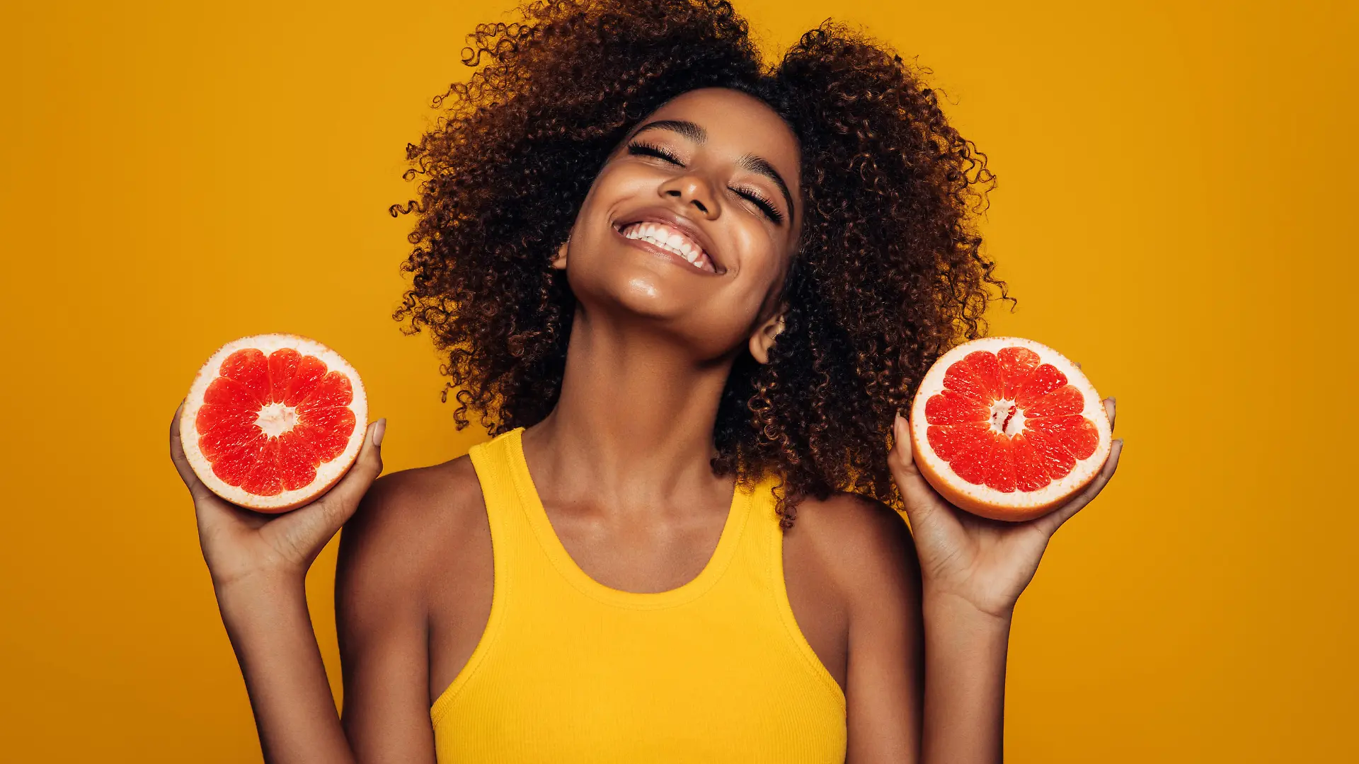 Beautiful afro girl with grapefruit