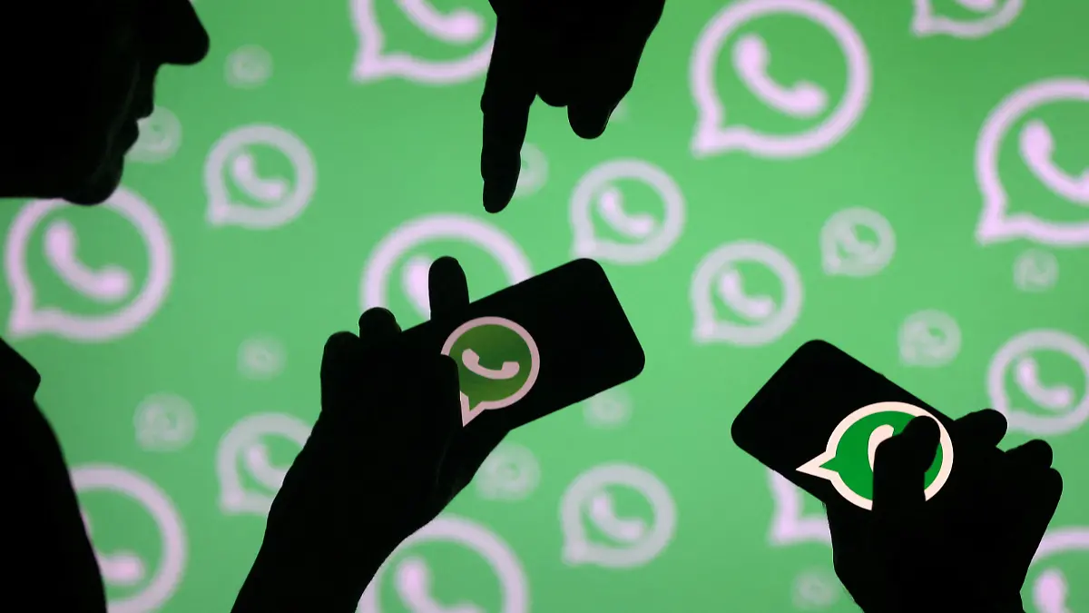 FILE PHOTO: Men pose with smartphones in front of displayed Whatsapp logo in this illustration September 14, 2017. REUTERS/Dado Ruvic/File Photo