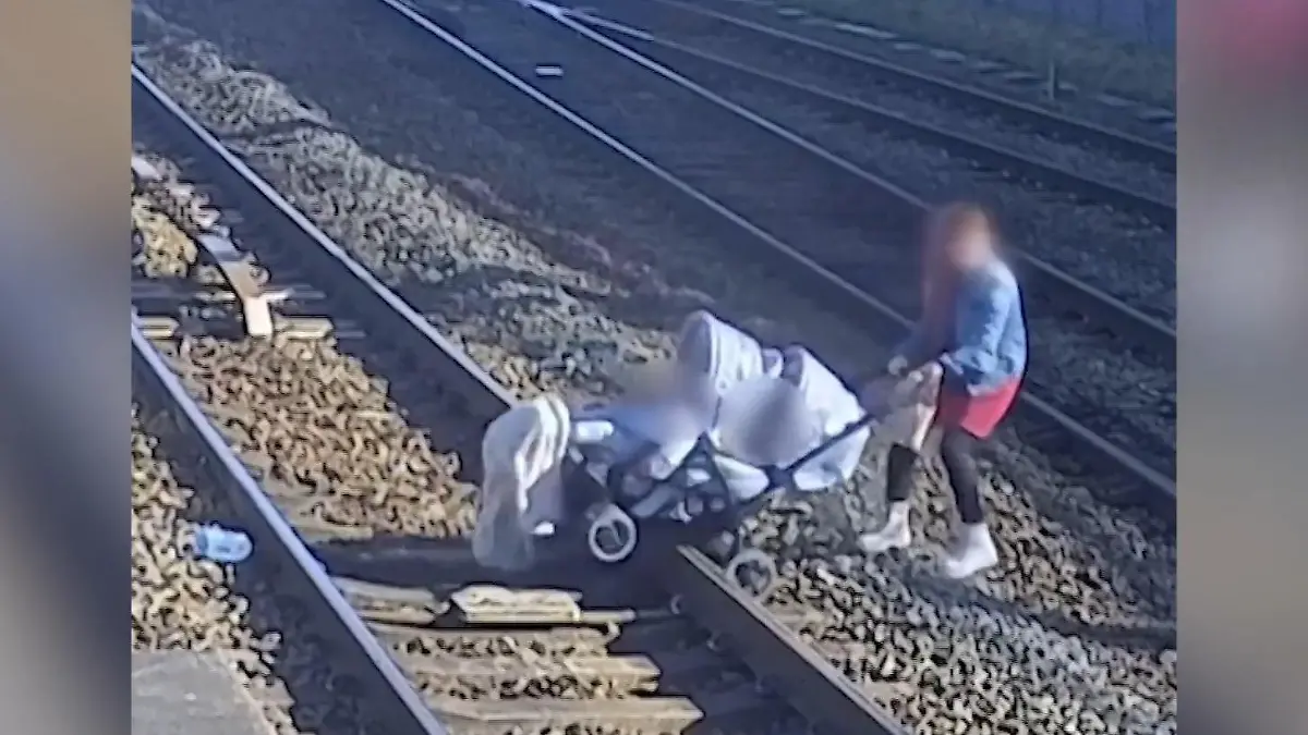 Völlig wahnsinnig! Frau schleift Kinderwagen über Bahngleise Sie riskiert nicht nur ihr Leben!