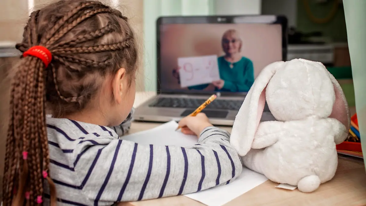 Pretty stylish schoolgirl studying math during her online lesson at home, social distance during quarantine, self-isolation, online education concept